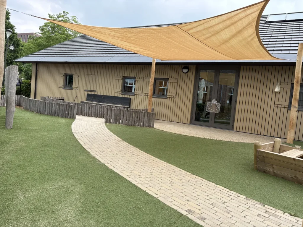 Achtertuin met schaduwdoek en bestraat pad