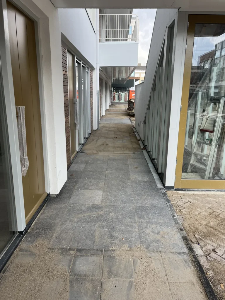 Bestraat zijpad tussen de woningen