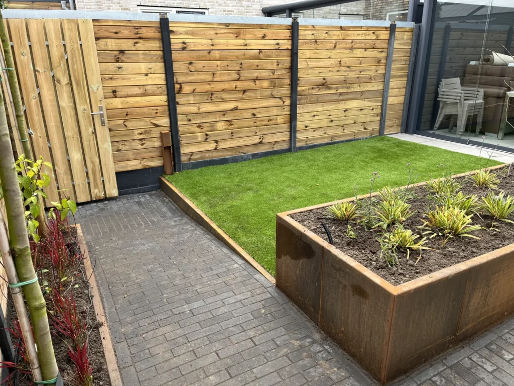 Houten schutting met terras en border