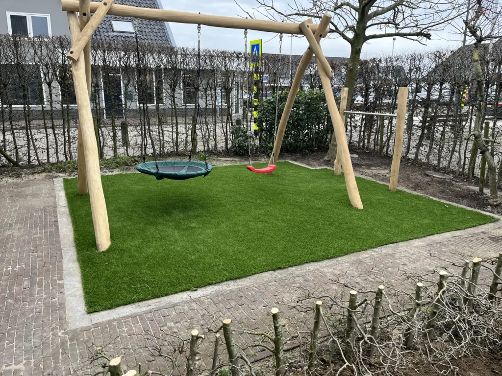Speelhoek met nestschommel en kunstgras